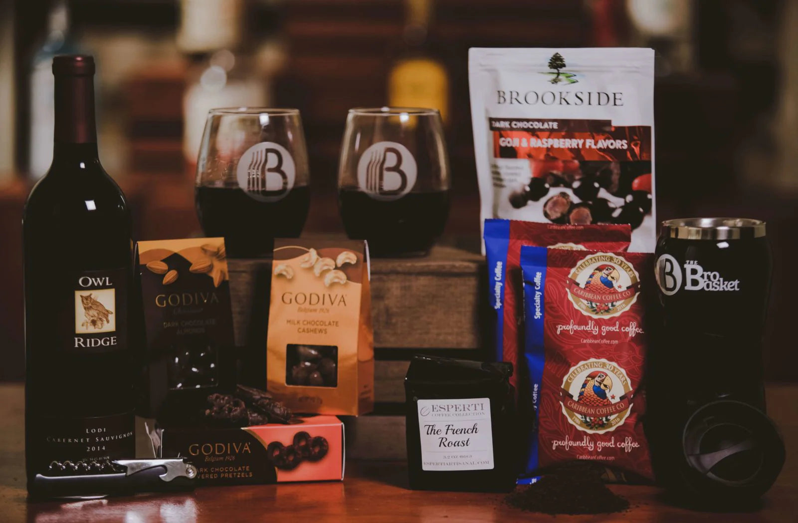 Assorted gourmet gift sets from BroBasket featuring Owl Ridge Cabernet Sauvignon wine, Godiva chocolates, Brookside dark chocolate goji and raspberry flavors, Caribbean coffee packs, The French Roast coffee, branded wine glasses, and a travel mug.